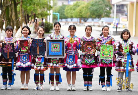 △2019年3月22日,广西融水苗族自治县民族中学女童班的学生展示刺绣作品。