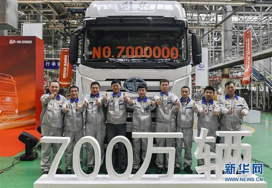 一汽解放职工与第700万辆解放卡车合影留念(2018年11月30日摄)。新华社记者 许畅 摄
