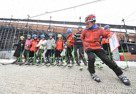 在四川省成都市新都区尖锋旱雪四季滑雪场，教练曹建（前）为队员们示范技术动作（2月25日摄）。新华社记者 王曦 摄