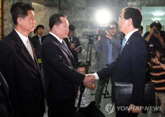 朝韩代表团团长在会谈前握手，左为李善权，右为赵明均。（图源：韩联社）