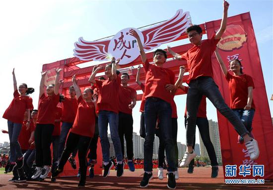 安徽淮南市第二中学学生穿越“成人门”（2018年5月4日摄）。新华社发（陈彬 摄）