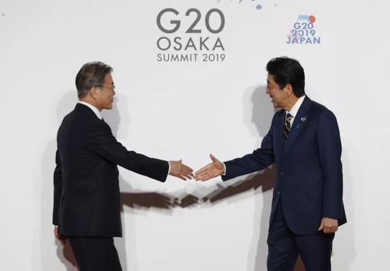 6月28日,在日本大阪,日本首相安倍晋三(右)欢迎韩国总统文在寅。新华社发
