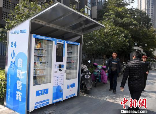 资料图:市民从24小时自动售药机旁经过。 张斌 摄