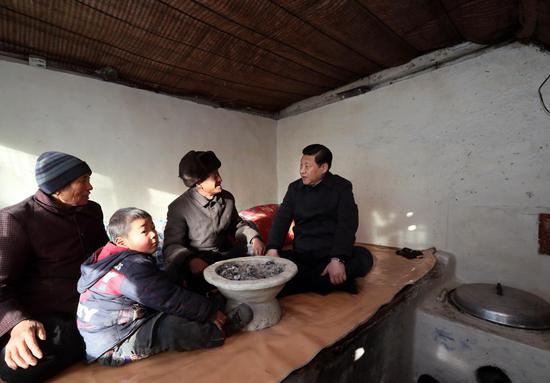 2012年12月30日,习近平坐在河北省阜平县龙泉关镇骆驼湾村困难群众唐荣斌家(右二)炕上,详细询问他们一年下来有多少收入,粮食够不够吃,过冬的棉被有没有,取暖的煤炭够不够,小孩上学远不远,看病方便不方便。来源:新华社