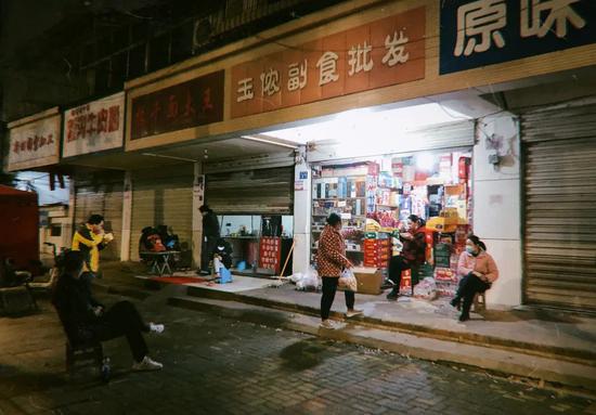 偏僻的街边，几名武汉市民正在用方言聊天。