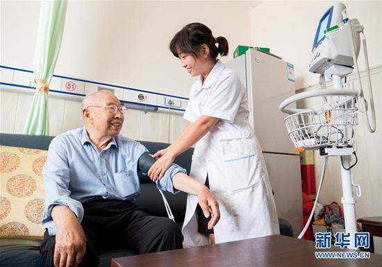 近年来，河北省武邑县积极引导医疗机构开展“医养结合”新型养老服务，让老人乐享幸福晚年。图为县医院医养中心工作人员在养老公寓为老人测量血压。新华社记者朱旭东摄