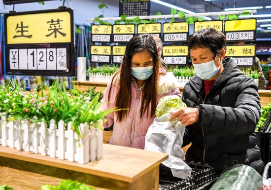 1月18日，居民在广西兴业县“老乡家园”配套建设的平价超市内购买蔬菜。新华社记者 曹祎铭 摄