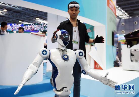 在全国大众创业万众创新活动周北京会场主题展上，一名工作人员在展示一款仿生机器人（2017年9月15日摄）。新华社记者 张晨霖 摄