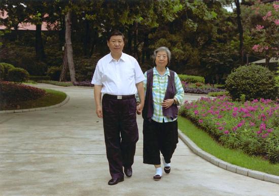 习近平陪母亲齐心散步。来源:新华社