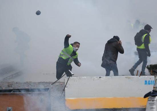 示威者向警戒线扔掷石块 （图源：卫报）