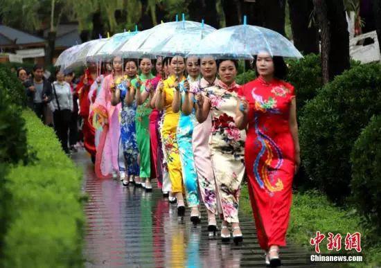 一些旗袍爱好者在牡丹园内走秀穿梭,引民众围观。 王中举 摄