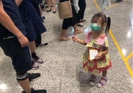 (图:在香港非法示威中,孩子被一些激进示威者当作“人肉屏幕”,身上贴满政治观点。)