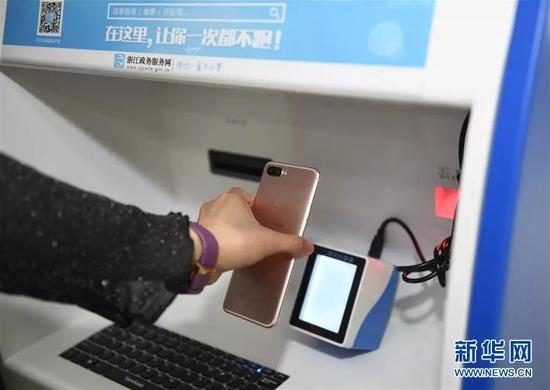 浙江省衢州市行政服务中心,市民通过自助机扫描支付宝手机客户端上领取的“居民身份证网上功能凭证”办理个人业务。来源:新华网  新华社记者 黄宗治 摄