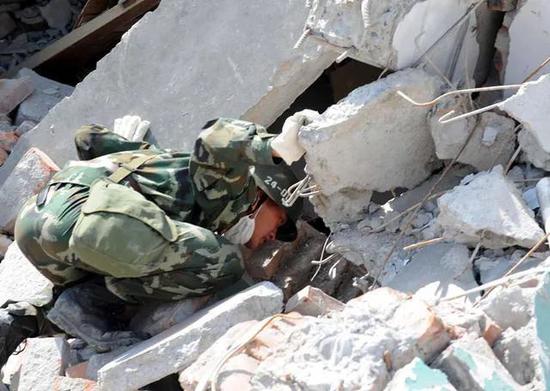 2008年5月14日，解放军战士在四川北川县中学的废墟里寻找并呼唤幸存的师生。图源：李晓果|新华社