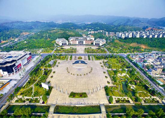 湖南省汝城县举债修建的爱莲广场,仅6棵银杏树就花了285万元,8根图腾石柱花了120万元。与广场相对的是县委县政府的办公大楼。图/《中国纪检监察报》