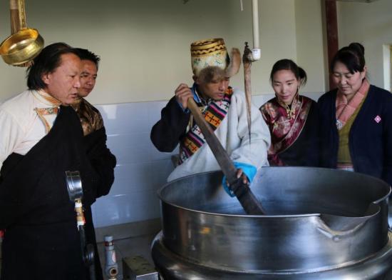 该遗产项目代表性传承人明珠(左)指导泷沐觉堪(制药师)煎熬“五味甘露”。关确才让 摄 中国非物质文化遗产保护中心供图