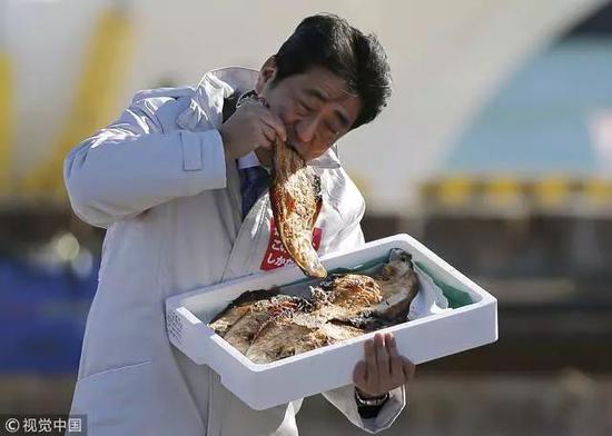 △2014年,首相安倍晉三爲自民黨造勢時吃當地烤魚