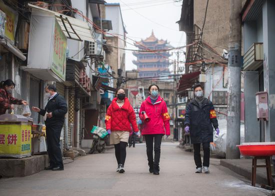 2月7日,在离武汉著名景点黄鹤楼不远的中华路街道西城壕社区,西城壕社区党委书记翁文静(右二)与志愿者柳莹(右三)、张琦(右一)上街进行防疫宣讲。新华社记者 肖艺九 摄