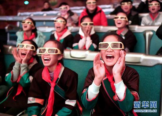在广西柳州市景行小学柳东校区，来自三江侗族自治县和融安县大山里的留守儿童观看3D动画片（1月4日摄）。当日，柳州市举行关爱留守儿童城市圆梦活动。新华社发（黎寒池 摄）