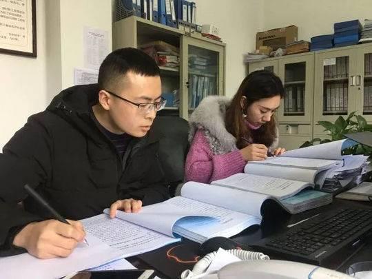 段治鑫(图左)与同事比对年终总结