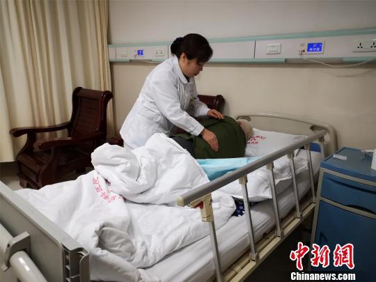 资料图:一名精神科护士帮患者拍背舒缓。 林馨 摄
