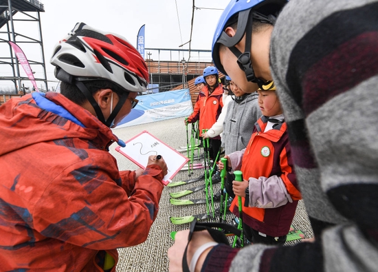 教练曹建（左一）在白板上画出滑降训练的路线（2月25日摄）。新华社记者 王曦 摄