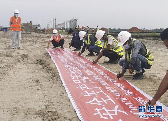 6月1日，在孟加拉国帕德玛大桥铁路连接线项目轨枕生产厂区，当地员工佩戴口罩参加安全生产月签名活动。新华社发