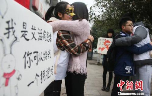 资料图:大学生扮“艾滋病患者”求拥抱,宣传防艾知识。曹正平摄