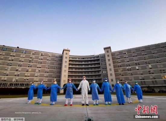 当地时间4月6日,意大利克雷莫纳一家医院的医务人员手牵手,向在新冠肺炎疫情中受影响的人们表示支持和致意。