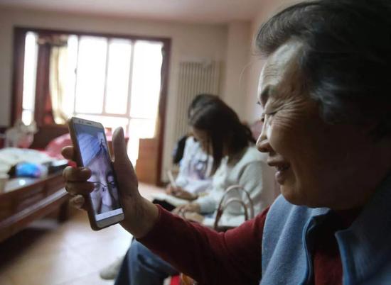 董存梅和找到的“勇敢者小队”最后一名成员,目前在新疆石河子生活的杨璐视频通话。新京报记者 王贵彬 摄