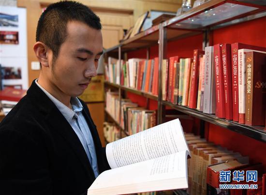 毛浩夫在翻阅党史书籍,补充自己的党史知识(2017年11月15日摄)。新华社记者 申宏摄