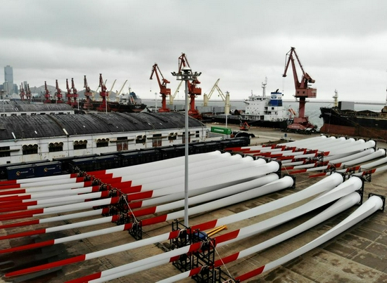 一批风电叶片排放在江苏连云港一码头等待装船（7月27日摄，无人机照片）。新华社发（王春 摄）