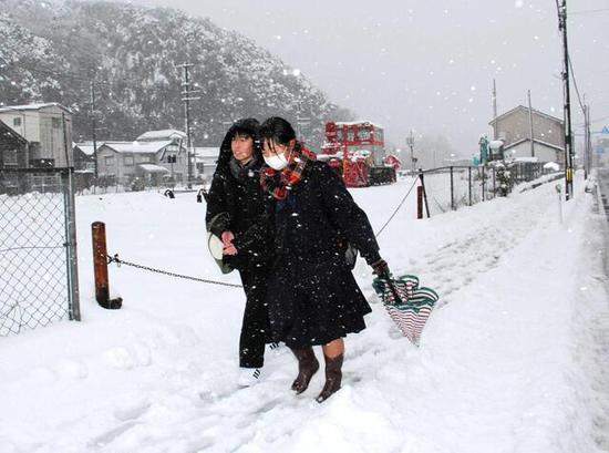  冒着大雪出行的日本民众（神户新闻社）