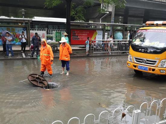 ▲上午11时30分许，上地十街东口抢险人员在抢修排水。新京报记者 王贵彬 摄