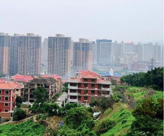 凤凰别墅山庄（近处）以及商品房&ldquo;名邦豪苑&rdquo;（远处高楼）。摄影/本刊记者黄孝光