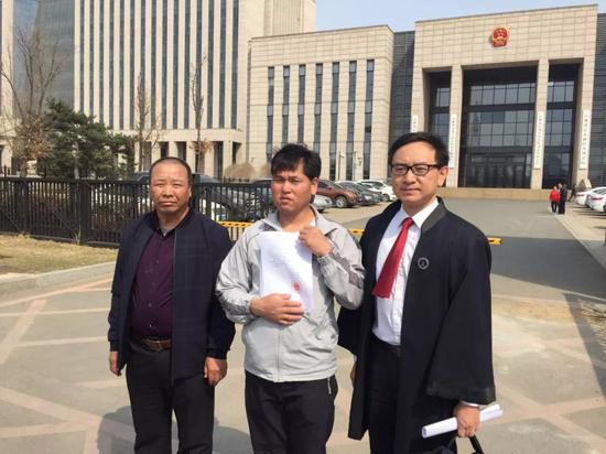 宣判后,刘忠林在律师与姐夫的陪同下走出法庭,向媒体出示无罪判决书。新京报记者王巍 摄