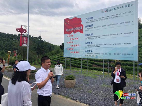  朱仁斌手持话筒向记者介绍鲁家村发展情况。中国青年网记者 唐希 摄 
