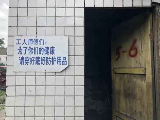 矿区墙上写着提醒工人戴好防护用品的标语。 新京报记者 王翀鹏程 摄