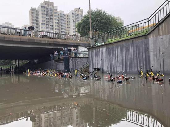 ▲回龙观地铁A口处，共享单车被淹过了车身。新京报记者 姚为 摄