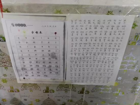▲宿舍墙上贴着的汉语拼音和简单汉字，都是薛志刚一笔一划工工整整抄下来的。本报记者蒋菡 摄