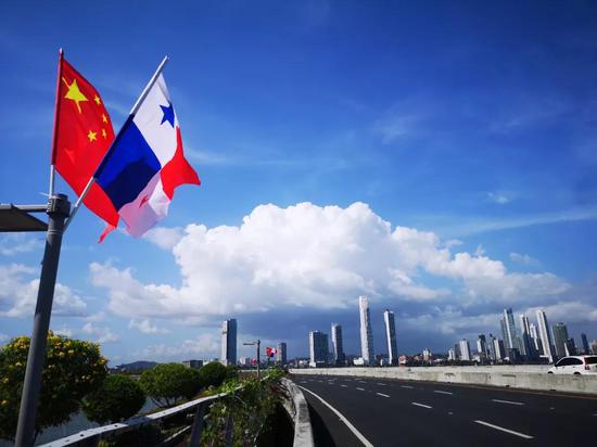 △公路上悬挂的中巴两国国旗迎风飘扬。(央视记者周志国拍摄)