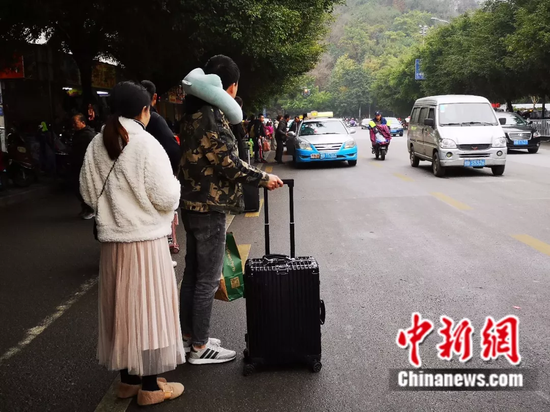 2月13日,民众在柳州市汽车总站前打车。