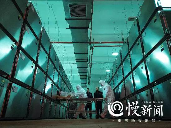 ▲巩强(左)和王小伟(右)把待检尸体拉出来,接下来他们会走向解剖室,揭开一个死亡的真相