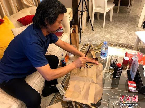 沈巍在废弃包装纸上练字。廖雪芝 摄