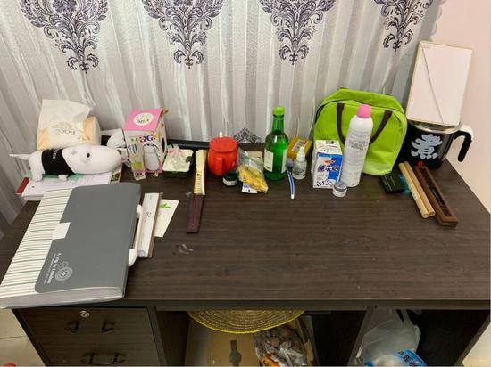 这是记者拍摄的黄文秀驻村宿舍内的书桌,除了简单的日用品外,就是厚厚的驻村资料。