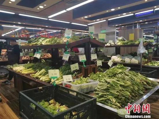  图为北京一家超市里，各种蔬菜整整齐齐地摆在货架上。谢艺观 摄