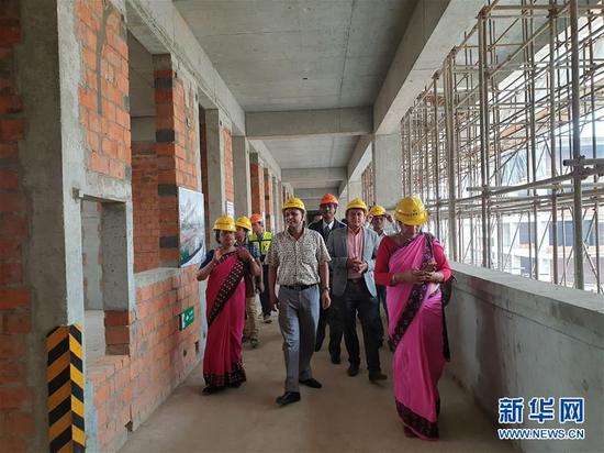 2019年5月24日,学校老师跟其他工作人员一起参观由中国协助重建的尼泊尔百年名校加德满都杜巴中学校园。新华社发(苏尼尔·夏尔马摄)