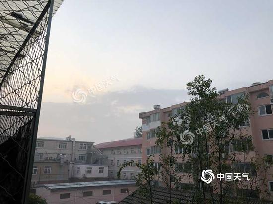 今晨的北京，阳光在云层里若隐若现。