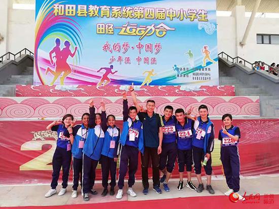 图为快三彩查app—官方网址22270.COM,北京援疆教师刘军岗在运动会上与学生们合影。北京援疆指挥部供图