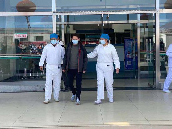 张某某在医生陪伴下,走出自治区第三人民医院。徐驭尧摄